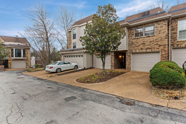 401 Bowling Ave Unit 31, Nashville, TN 37205 - townhome / multi-family property featuring concrete driveway, an attached garage, and brick siding