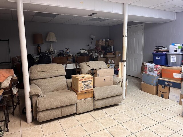 finished below grade area featuring tile patterned flooring and a drop ceiling