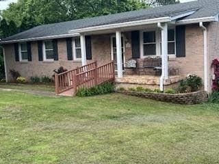 ranch-style home featuring a front lawn, a porch, and brick siding
