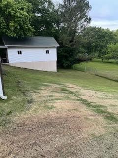 view of green lawn featuring an outbuilding