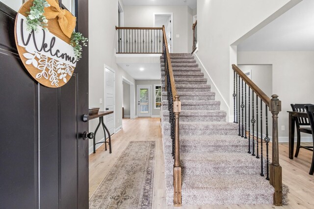 1289 Southside Rd, Southside, TN 37171 - entrance foyer with stairway, baseboards, a high ceiling, and wood finished floors