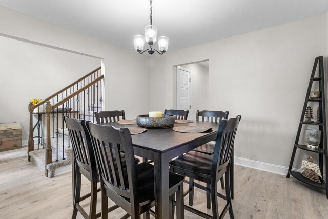 1289 Southside Rd, Southside, TN 37171 - dining area with light wood-style flooring, baseboards, stairs, and an inviting chandelier