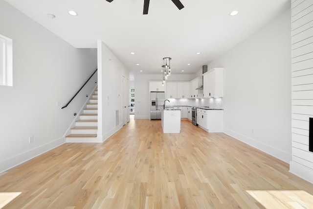 1815 14th Ave N Unit B, Nashville, TN 37208 - unfurnished living room featuring light wood-style floors, baseboards, ceiling fan, and stairs