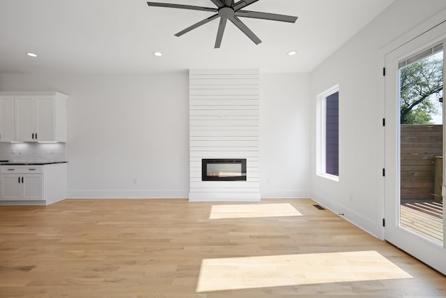 1815 14th Ave N Unit B, Nashville, TN 37208 - unfurnished living room with light wood-type flooring, a ceiling fan, baseboards, and a fireplace