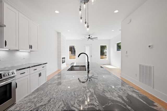 1815 14th Ave N Unit B, Nashville, TN 37208 - kitchen with backsplash, stainless steel electric range, a sink, white cabinetry, and visible vents