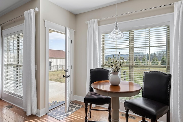 dining room featuring visible vents, baseboards, a notable chandelier, and wood finished floors