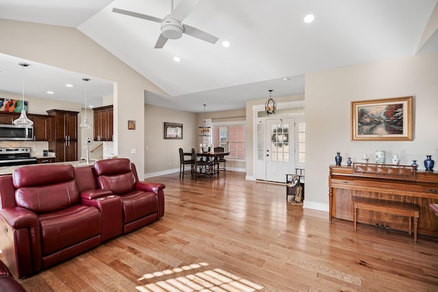 living area with light wood-style flooring, baseboards, vaulted ceiling, and ceiling fan