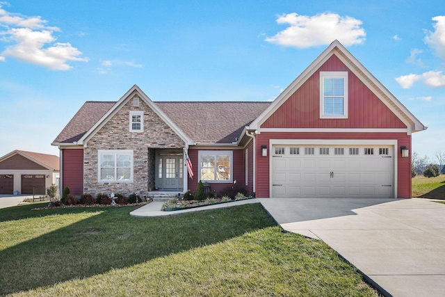 view of front of property with stone siding, a garage, concrete driveway, a front lawn, and roof with shingles