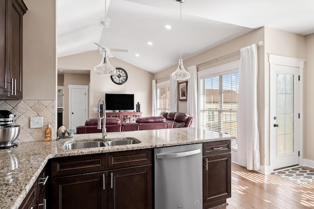 kitchen with a sink, dark brown cabinets, open floor plan, and dishwasher