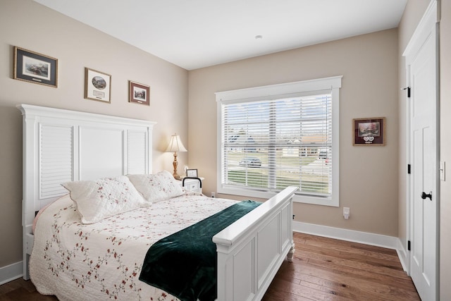 bedroom featuring baseboards and dark wood finished floors