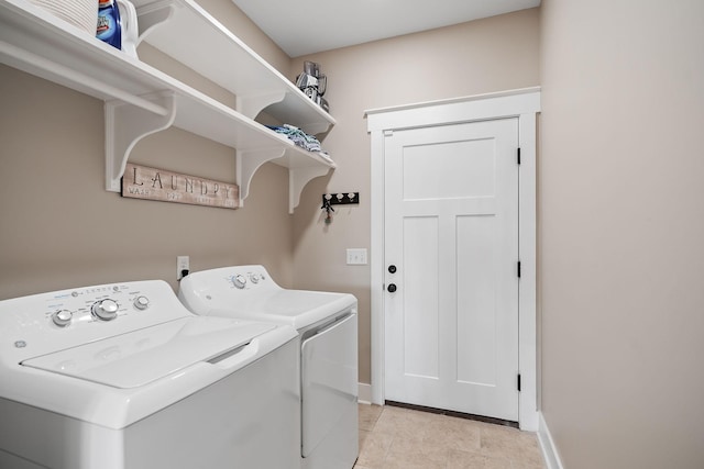 washroom featuring light tile patterned floors, washer and clothes dryer, laundry area, and baseboards