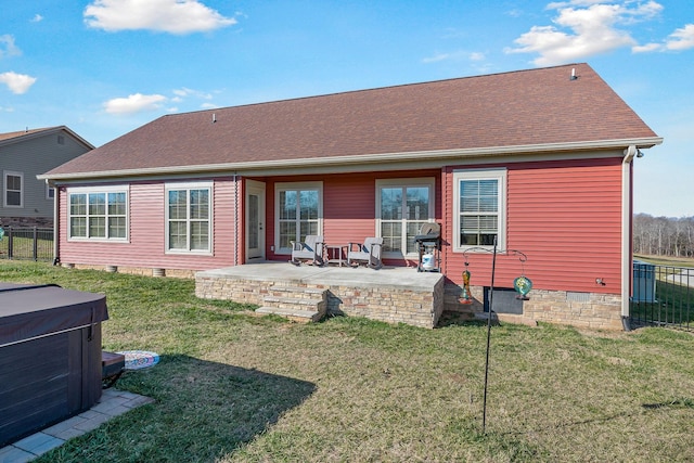 rear view of property featuring crawl space, a patio area, fence, and a hot tub