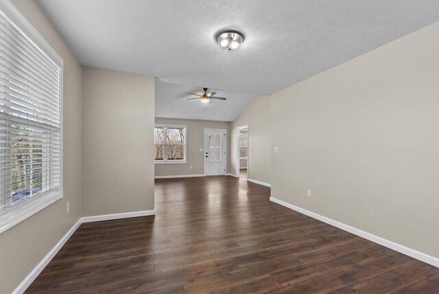 530 S Oak St, Hohenwald, TN 38462 - empty room featuring dark wood-style flooring, baseboards, vaulted ceiling, a textured ceiling, and a ceiling fan
