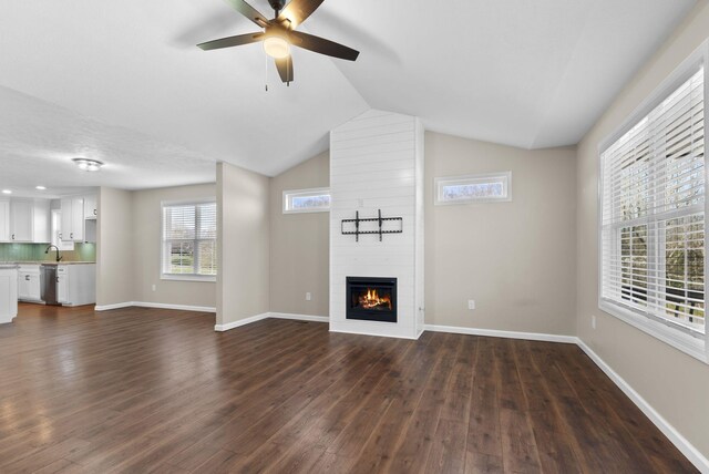 530 S Oak St, Hohenwald, TN 38462 - unfurnished living room with dark wood-style flooring, a large fireplace, baseboards, and a ceiling fan