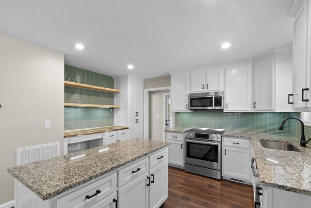 530 S Oak St, Hohenwald, TN 38462 - kitchen with dark wood-type flooring, appliances with stainless steel finishes, a sink, and white cabinets