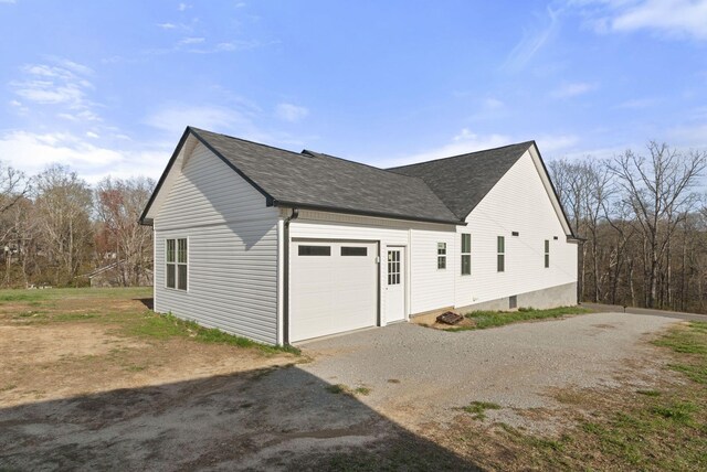 530 S Oak St, Hohenwald, TN 38462 - view of side of home with roof with shingles, driveway, and an attached garage