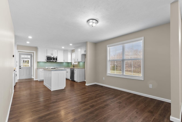 530 S Oak St, Hohenwald, TN 38462 - kitchen with dark wood-style floors, white cabinetry, backsplash, and appliances with stainless steel finishes