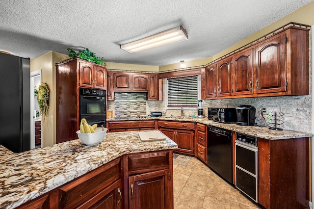 1712 Lake Grassland W, Gallatin, TN 37066 - kitchen featuring tasteful backsplash, light stone countertops, a textured ceiling, black appliances, and a sink