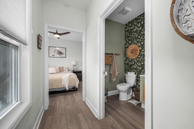 bathroom with visible vents, toilet, baseboards, and wood finished floors