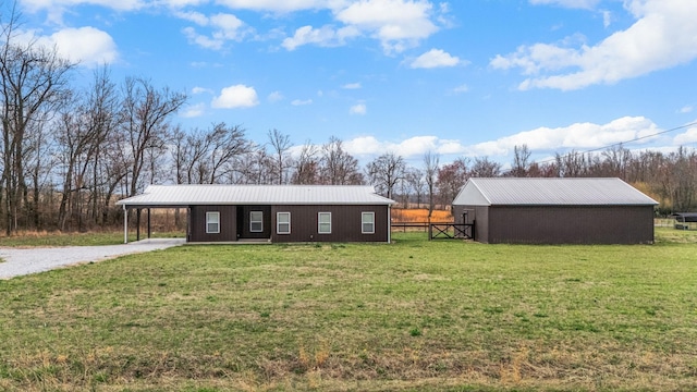 view of front of property with metal roof, a carport, a front lawn, and a pole building