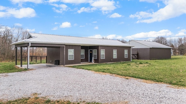 view of front of house featuring driveway, an outdoor structure, a front yard, metal roof, and a carport