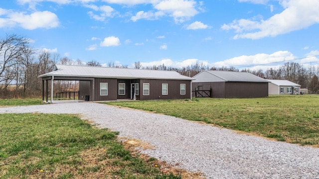 single story home with a carport, a front lawn, driveway, and metal roof