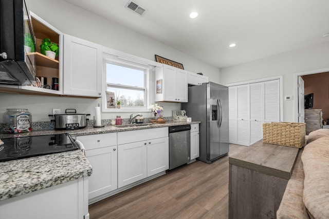 kitchen featuring visible vents, appliances with stainless steel finishes, white cabinetry, and a sink