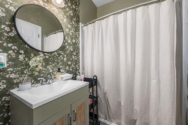 bathroom featuring vanity and wallpapered walls