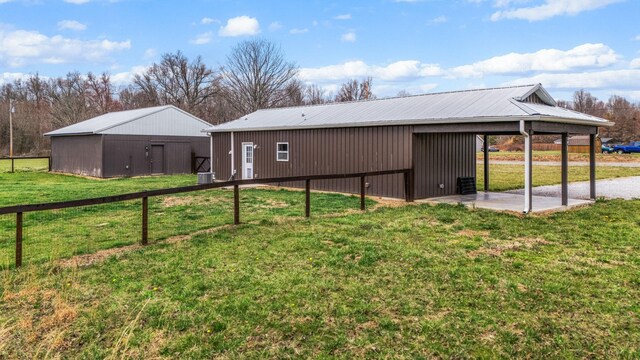 back of property with an outbuilding, a lawn, and an outdoor structure