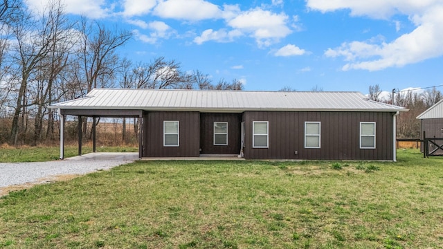 view of front of property featuring an attached carport, a front lawn, driveway, and metal roof