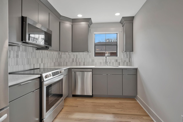 1815 Martin St Unit A, Nashville, TN 37203 - kitchen with stainless steel appliances, gray cabinetry, decorative backsplash, light countertops, and light wood finished floors