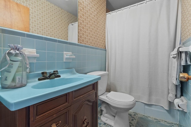 full bath with vanity, a wainscoted wall, wallpapered walls, tile walls, and toilet