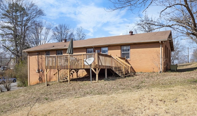 rear view of house with a deck, stairway, brick siding, and a chimney