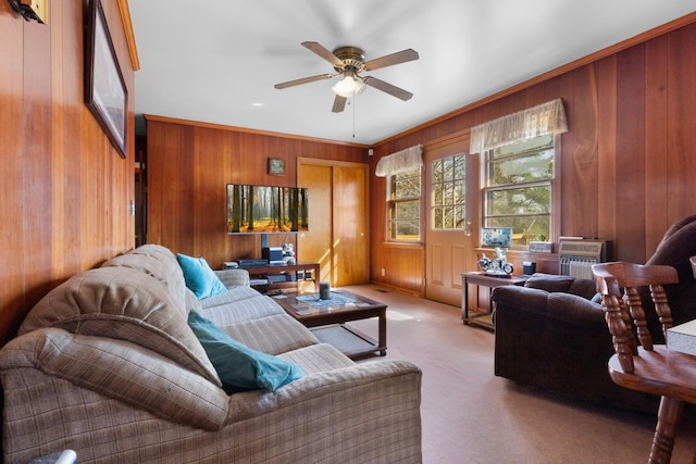 carpeted living room featuring wooden walls and a ceiling fan