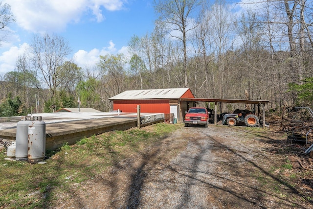 4897 Sulphur Creek Rd, Nashville, TN 37218 - view of yard featuring a pole building, an outbuilding, a wooded view, and dirt driveway