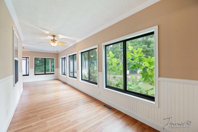 unfurnished sunroom with visible vents and ceiling fan