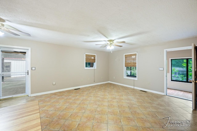 spare room with visible vents, a textured ceiling, ceiling fan, and light tile patterned flooring