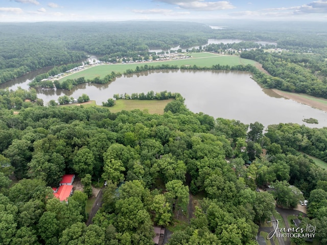 drone / aerial view with a forest view and a water view