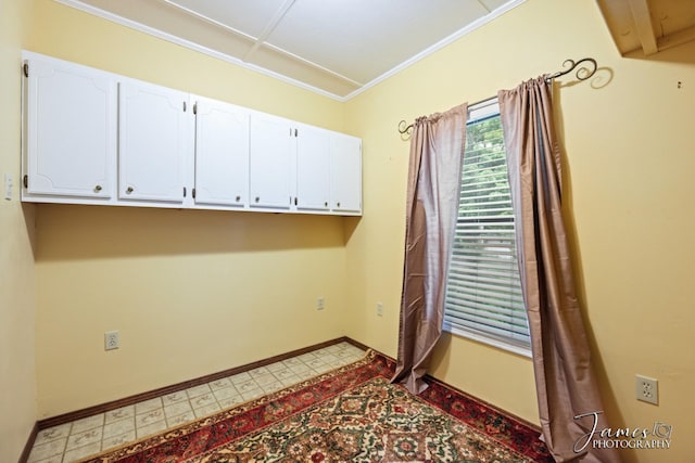laundry area featuring baseboards, light floors, and crown molding