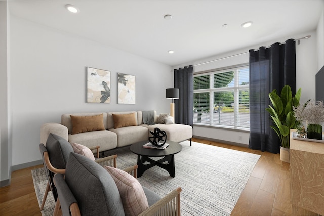 living room with light wood finished floors, baseboards, and recessed lighting