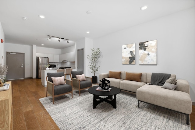 living area featuring light wood-type flooring and recessed lighting