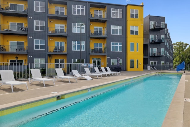 community pool featuring fence and a patio area