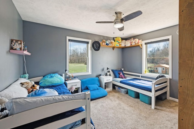 bedroom with carpet, a ceiling fan, and a textured ceiling
