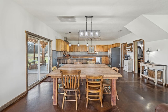 dining room featuring visible vents, baseboards, and finished concrete floors