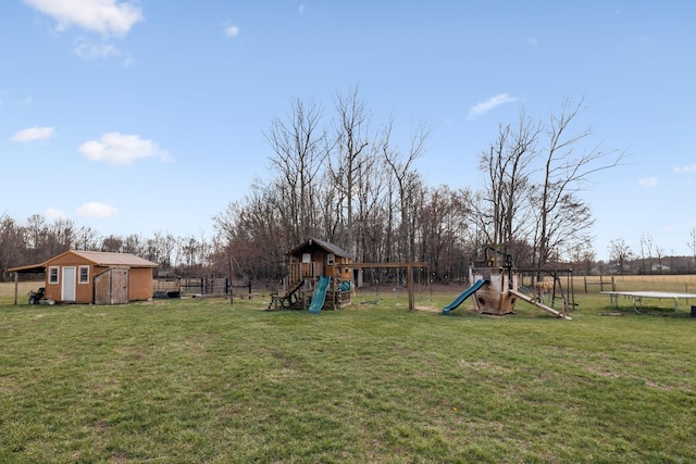 view of yard featuring an outbuilding, a playground, a trampoline, and fence