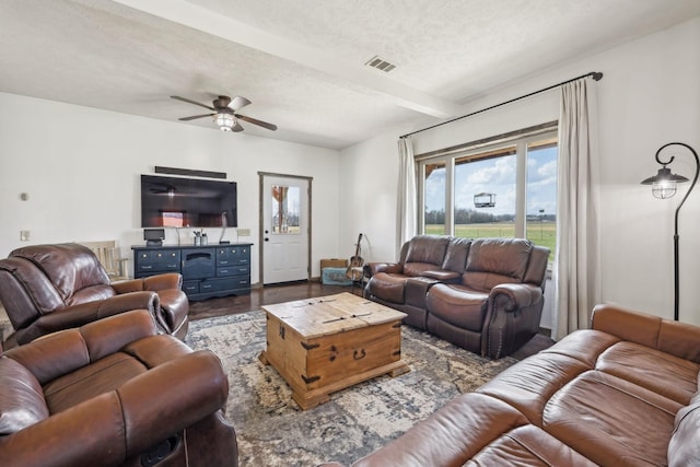 living room with visible vents, beam ceiling, a textured ceiling, wood finished floors, and ceiling fan