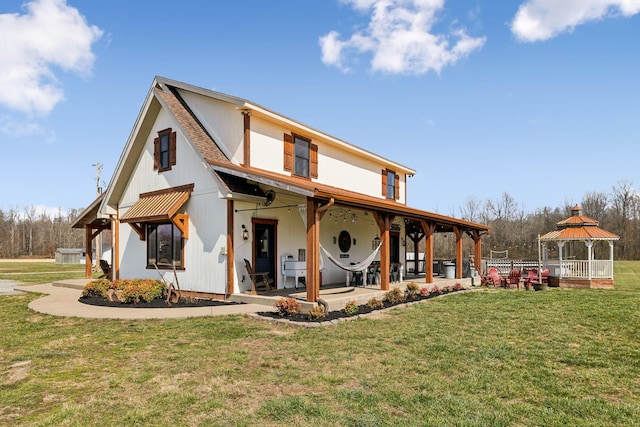 view of front of house with a gazebo, a patio, roof with shingles, and a front lawn