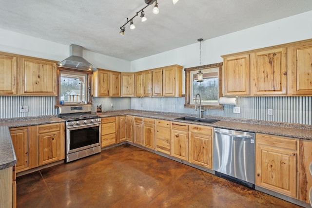 kitchen featuring a sink, appliances with stainless steel finishes, wall chimney exhaust hood, and a healthy amount of sunlight