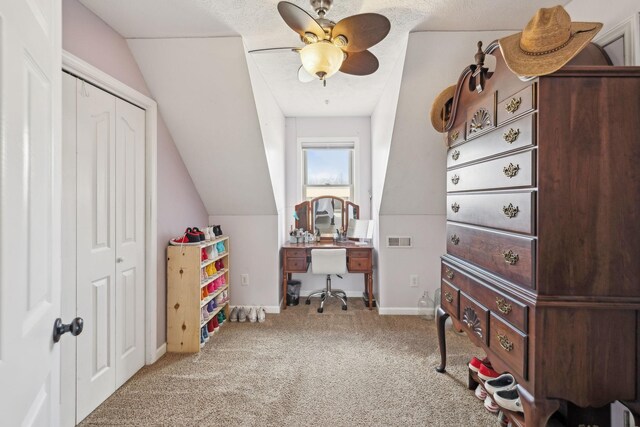 interior space featuring visible vents, a ceiling fan, carpet, and vaulted ceiling