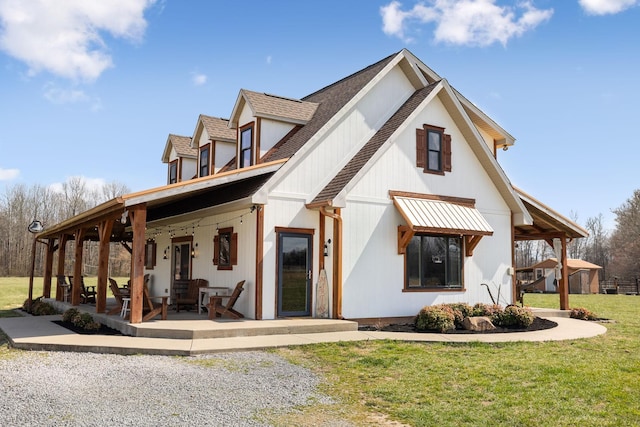 modern farmhouse style home with a patio, a front yard, and a shingled roof
